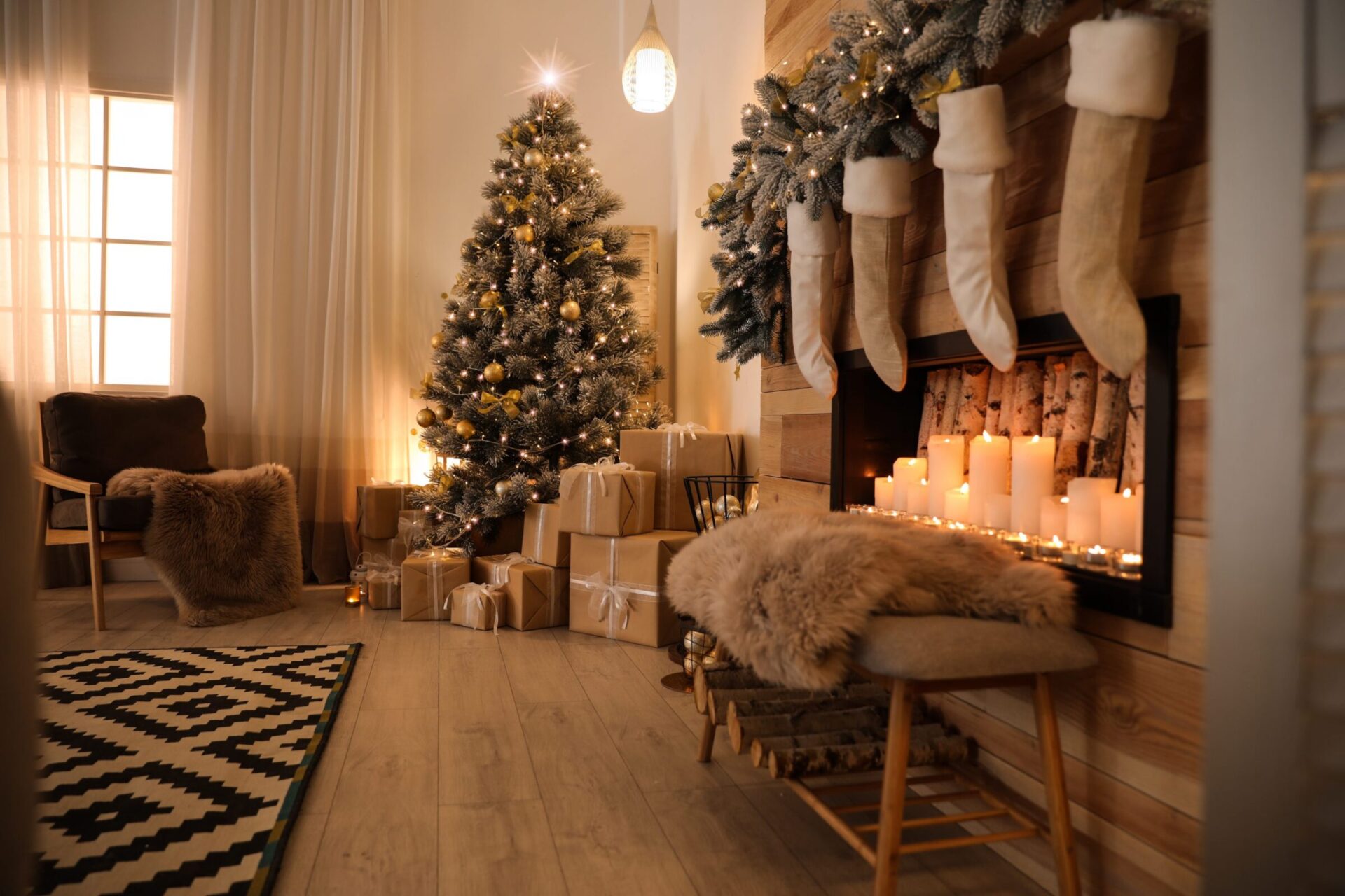 A cozy Christmas setting with a decorated tree, gifts, lit candles in a faux fireplace, stockings hanging, and warm lighting creating a festive atmosphere.