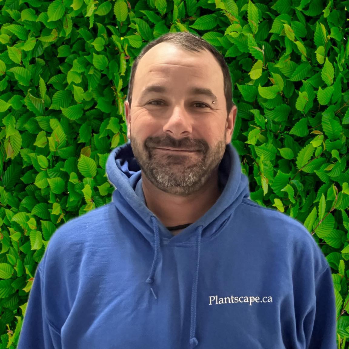 A smiling person in a blue hoodie stands in front of a leafy green backdrop. The hoodie has "Plantscape.ca" written on it.