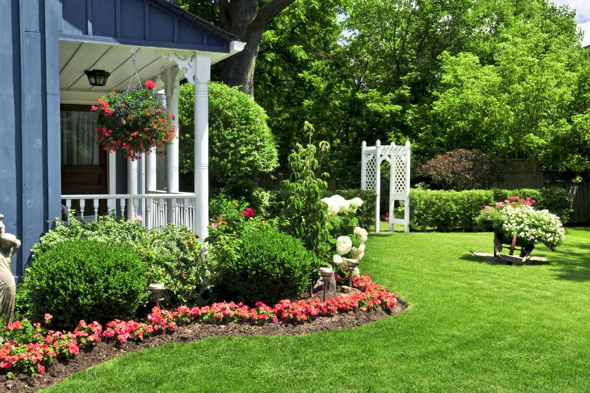 landscaped residential front yard in all four seasons – snow, spring bloom, summer green, and fall color
